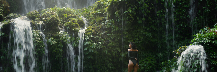 Back View of Woman in Jungle by Waterfalls at Banyu Wana Amertha, Bali