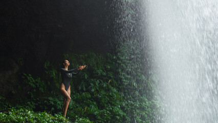 Woman in Bodysuit Playing With Waterfall Mist in Bali s Jungle Environment