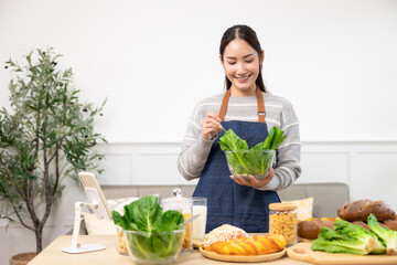 Asian woman  drinking milk and eating vegetable  breakfast  in kitchen at home .