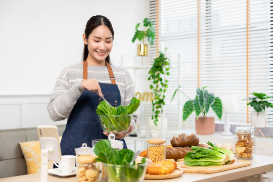 Asian woman  drinking milk and eating vegetable  breakfast  in kitchen at home .