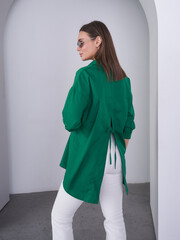 Striking green outfit showcases a confident model in a modern studio setting