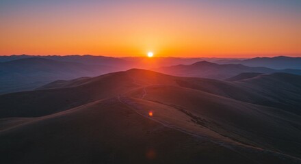 Vibrant Sunset Over Rolling Hills and Distant Mountains