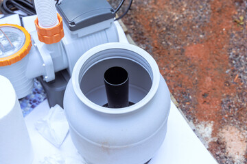 Installation process shows filtration system component ready for connection in swimming pool...