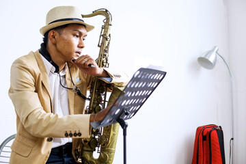 Portrait Of Saxophonist Guy Thinking And Writing Notes On Sheet