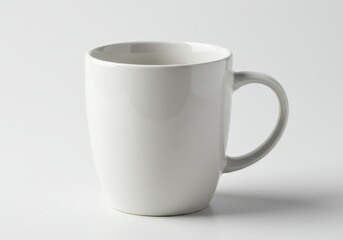 Simple still life of a white ceramic mug with a handle on a white background in a studio setting