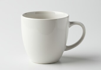 Obraz premium A simple white ceramic mug with a handle sits on a white surface in a studio setting