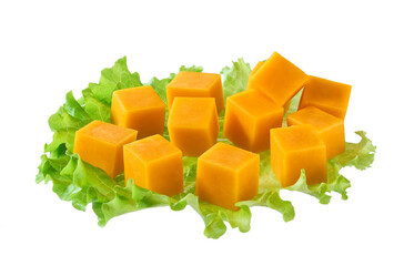 cheddar cheese sliced ​​into cubes with lettuce leaves isolated.