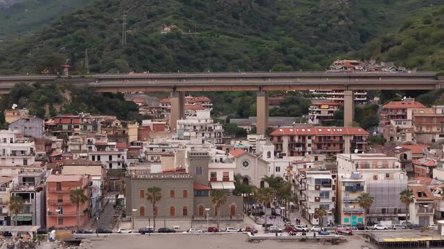 Charming coastal town with hillside homes and a bridge in Letojanni, Sicily, Italy
