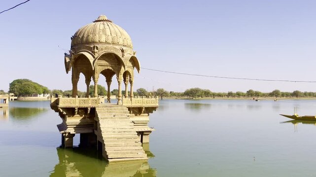 Gadsisar Lake in Jaisalmer sparkles under the Rajasthan sun, mirroring ancient temples and peaceful pavilions. Calm waters, migratory birds, and golden hues enhance its timeless desert beauty India