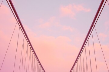 Fototapeta premium Pastel pink suspension bridge view under a soft sky.