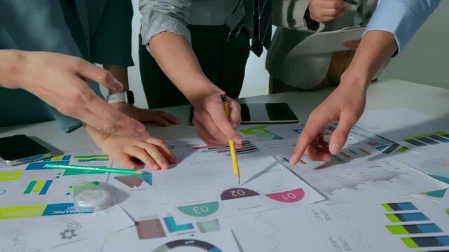 Team of business people working together in the meeting room office analysts strategizing on charts and data. Financial analysts discuss bars and graphs, using calculator to analyze data