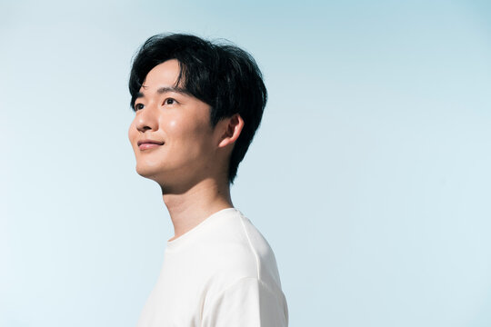 夏の日差しの中にいる20代の日本人男性のポートレート