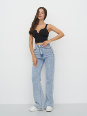 A female model stands elegantly in a fashion studio, exuding confidence