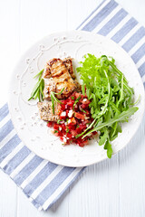 Fried pork tenderloin with tomato salsa. Bright background. Close up.	