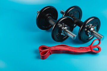 Weights and resistance bands arranged on a blue background