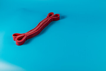 Red exercise band on a blue surface for fitness training