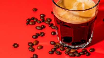Aromatic espresso with scattered beans on vivid red evokes Italian Ferragosto celebrations and International Coffee Day indulgence