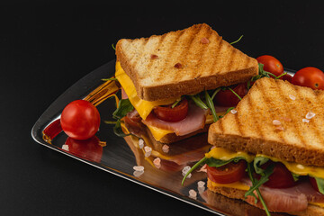 Delicious grilled sandwich with cheese, ham, and fresh vegetables for brunch
