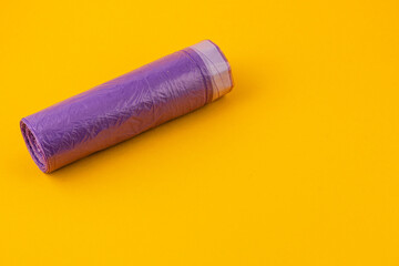 Bright purple plastic roll on vibrant yellow background
