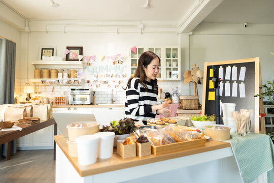 Small business owners are selling .Asian bakery  cake shop owner enjoy posting picture and review her cake on social media or online marketing streaming publish for advertising small business making m