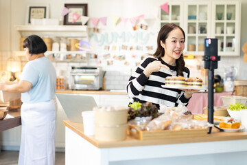 Small business owners are selling .Asian bakery  cake shop owner enjoy posting picture and review her cake on social media or online marketing streaming publish for advertising small business making m