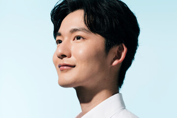 夏の日差しの中にいる白シャツを着た若い日本人男性