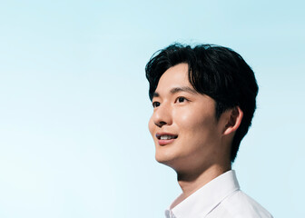 夏の日差しの中にいる白シャツを着た若い日本人男性