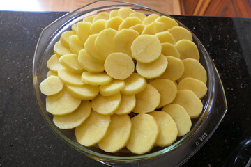 Layers of sliced potatoes placed on top of the lamb and vegetables before being put in the oven to cook a comforting regional dish of Lancashire Hot Pot

