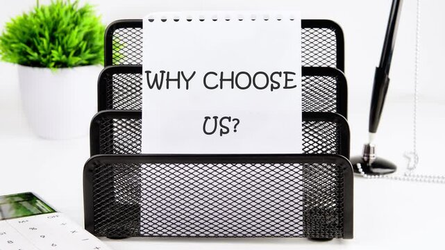 Animation of text WHY CHOOSE US on a note in a metal organizer on a desk next to a potted plant and stationery