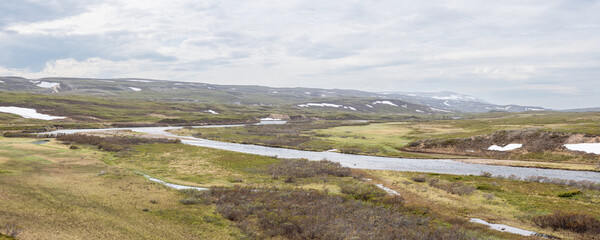 River Stuorrajohka flowing trough wet natural meadows in the Varangerhalvøya Natural Park, Northern Norway