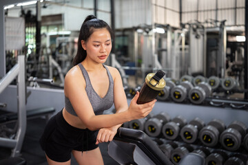 Fototapeta premium A woman in workout clothes drinking a health drink