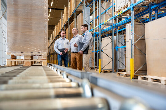 Employees having a meeting in a warehouse setting