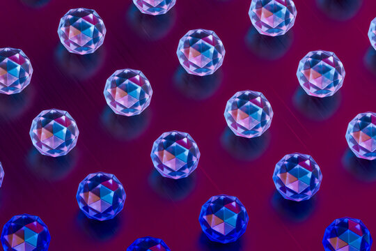 Colorful glass spheres arranged in a geometric pattern with neon reflections