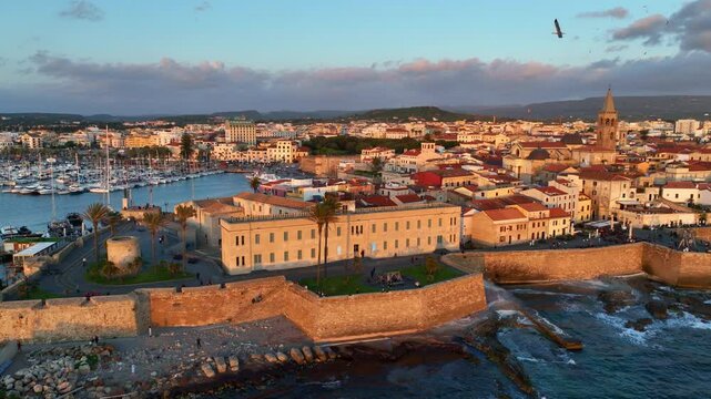 Alghero port and old town in Sardinia, aerial view, vacations in Sardinia, Italy, drone view of coastal ancient town in Sardegna, sunset in Alghero