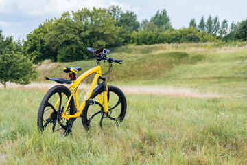 Obraz premium A yellow mountain bike costs green grass. nature background.