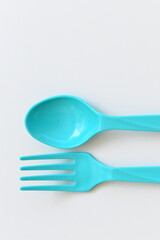 blue spoon and fork isolated on white background, plastic cutlery for picnic