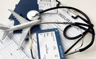 Fototapeta na wymiar Medical tourism. Travel insurance application form, stethoscope, plane model and flight tickets on black wooden table, closeup