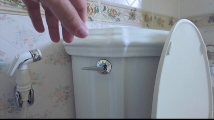 Flushing a Toilet –  close-up view of a toilet being flushed. Perfect for content related to hygiene, cleaning, water conservation, home maintenance, and plumbing tutorials.