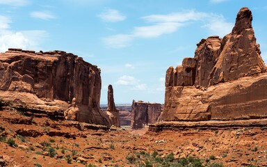 majestic red sandstone cliffs with layered geological formations under clear blue sky, desert...