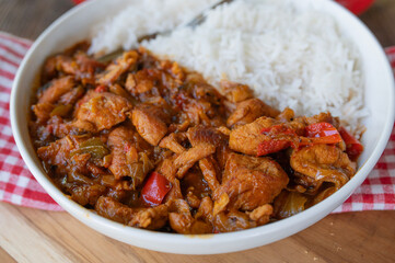 Slow cooked turkey breast with spicy bell pepper sauce and rice on a plate