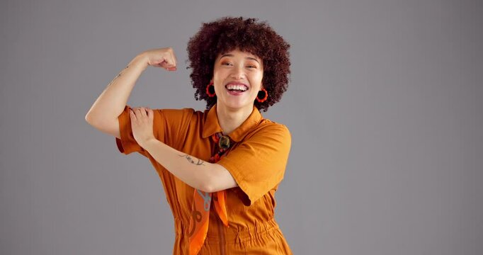 Wink, muscle and face of woman in studio for empowerment, strength and confidence. Happy, champion and portrait of person with strong arm flex for power, pride and achievement on gray background