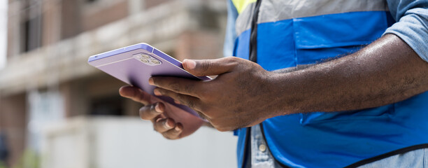 Construction site, hands holding tablet at housing estate projects under construction site. Banner of construction engineer working, planning, inspecting structure of architecture in construction site