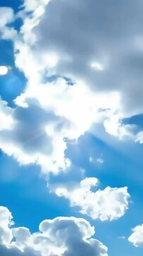 A dynamic timelapse of fluffy white clouds floating in a clear blue sky(Loop playback possible)