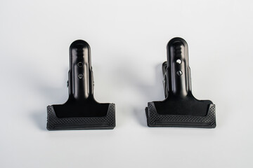 Black plastic spring clamp isolated on white background.