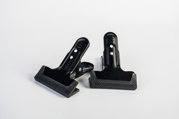 Black plastic spring clamp isolated on white background.