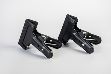 Obraz premium Black plastic spring clamp isolated on white background.