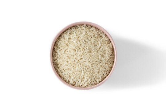 Basmati rice groats in a porcelain bowl , isolated on a white background , top view , place for text  .
