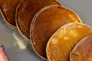 melting butter on baked pancakes, several pancakes made from milk with flour on which butter melts