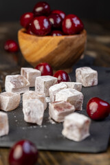 cubes of Turkish delight with the addition of dried red berries in powdered sugar