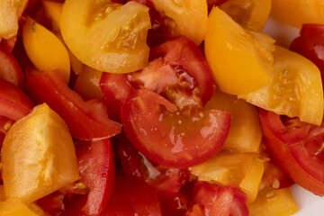 ripe tomatoes of red and yellow color during salad preparation, preparation of salad from sliced tomatoes